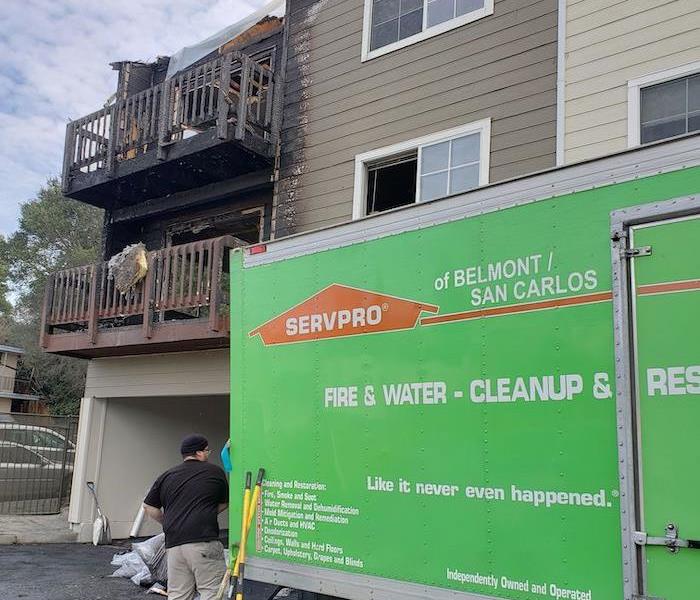 SERVPRO vehicle parked in front of home with fire damage